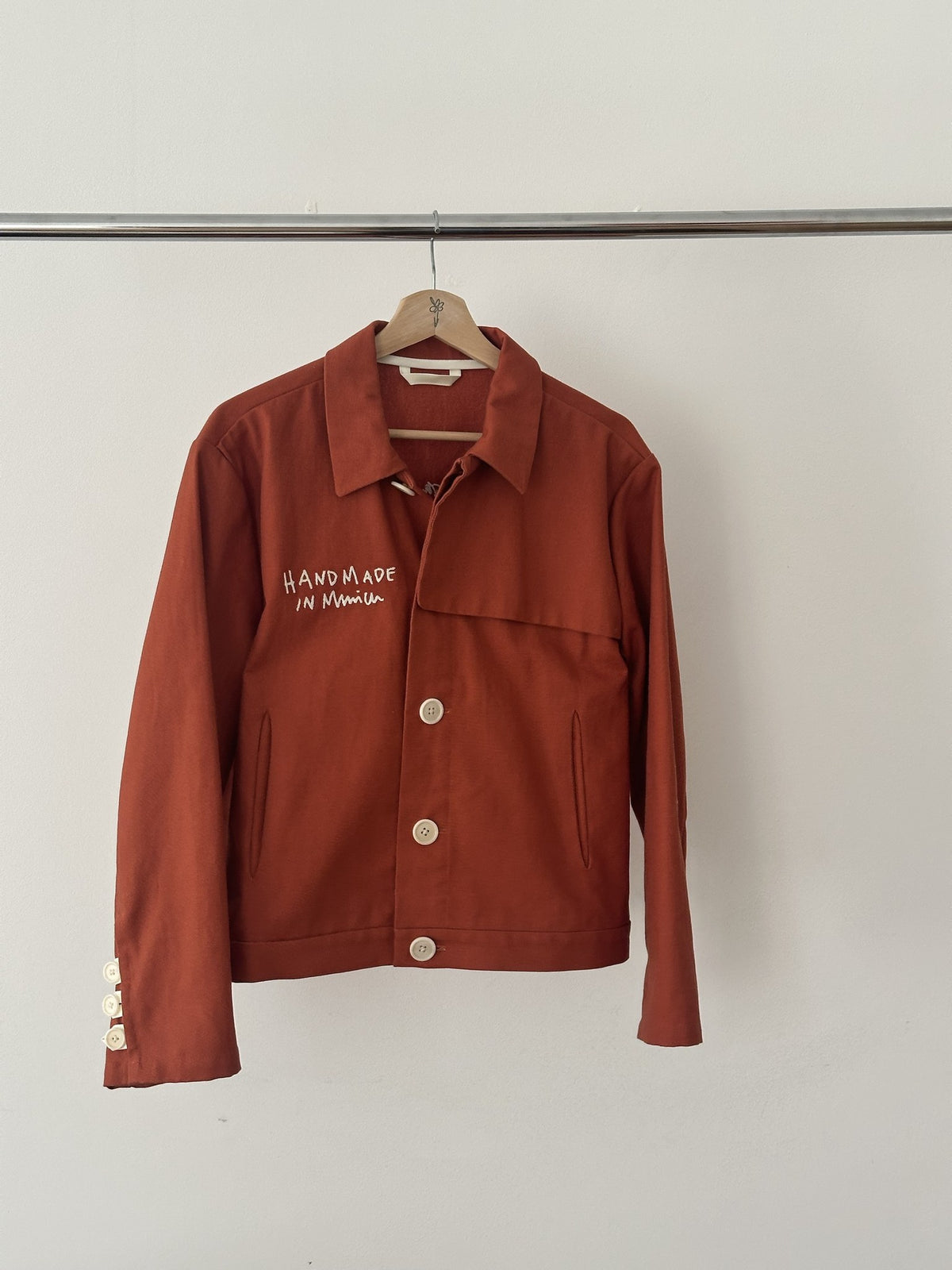 Atelierjacke Rostorange am Holzbügel, Vorderseite