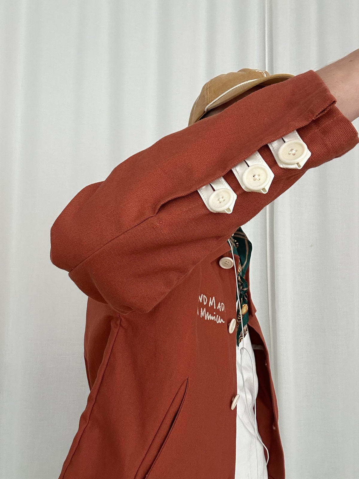 Ärmel der Atelierjacke Rostorange mit drei Satinlaschen und Steinnussknöpfen